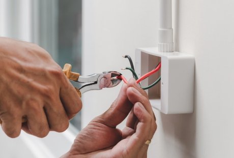 Electrician repairing electrical wiring inside a residential junction box
