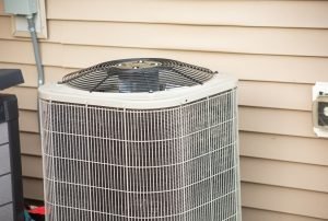 A residential air conditioning unit situated outside a home, showcasing the external fan and protective grilles. The AC unit is installed next to a beige siding wall, emphasizing a common setup in modern homes. AC maintenance, AC repair services, AC unit, residential cooling, HVAC system, air conditioner efficiency, Roseville air conditioning, Sacramento HVAC service, Rocklin cooling solutions, Folsom AC repair, Auburn HVAC maintenance, Citrus Heights air quality