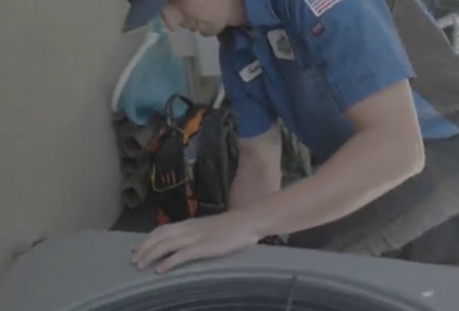 HVAC technician servicing outdoor residential heating and cooling unit