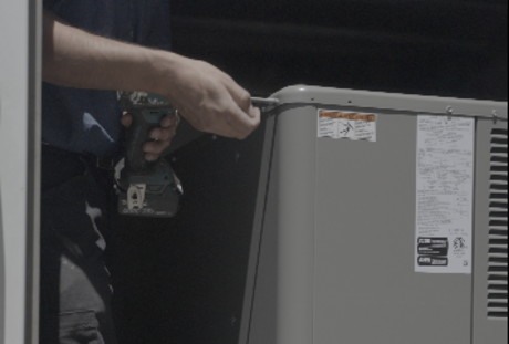 HVAC technician performing maintenance on residential heating and cooling unit