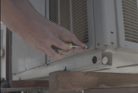 HVAC technician servicing outdoor heating and cooling condenser unit