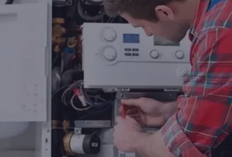 HVAC technician repairing a residential heating system boiler