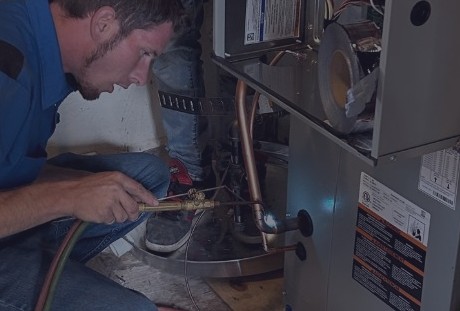 HVAC technician repairing residential furnace during home heating service
