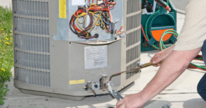 HVAC technician inspecting electrical components inside outdoor air conditioning unit