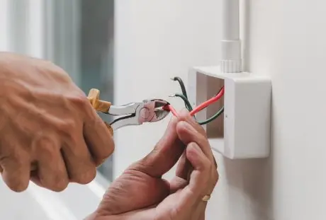 Electrician repairing electrical wiring inside a residential junction box
