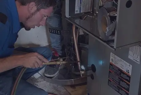 HVAC technician repairing residential furnace during home heating service